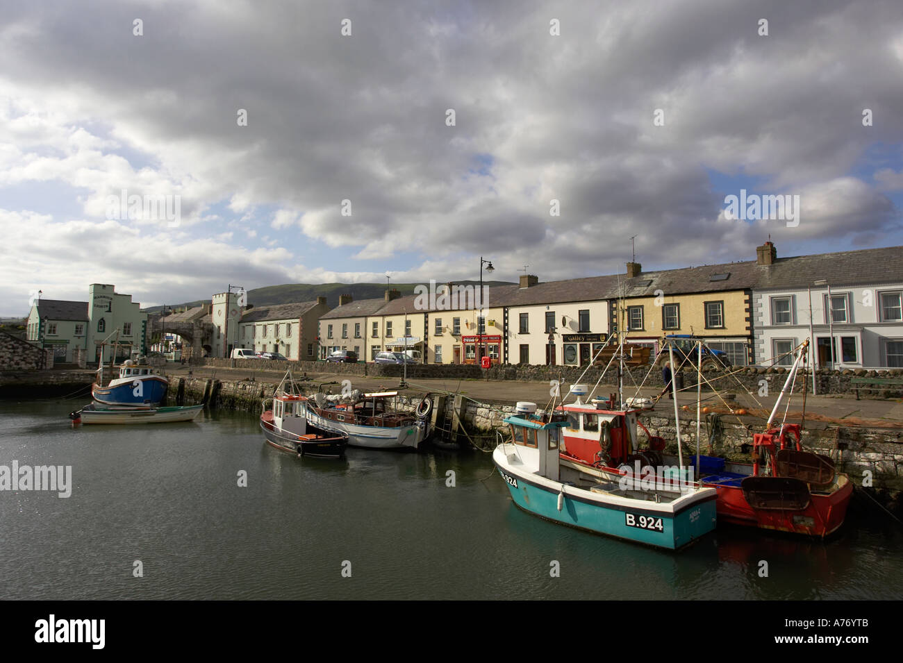 Boote im Hafen vor Reihe von bunten Häusern Carnlough Dorf county Antrim-Nordirland Stockfoto