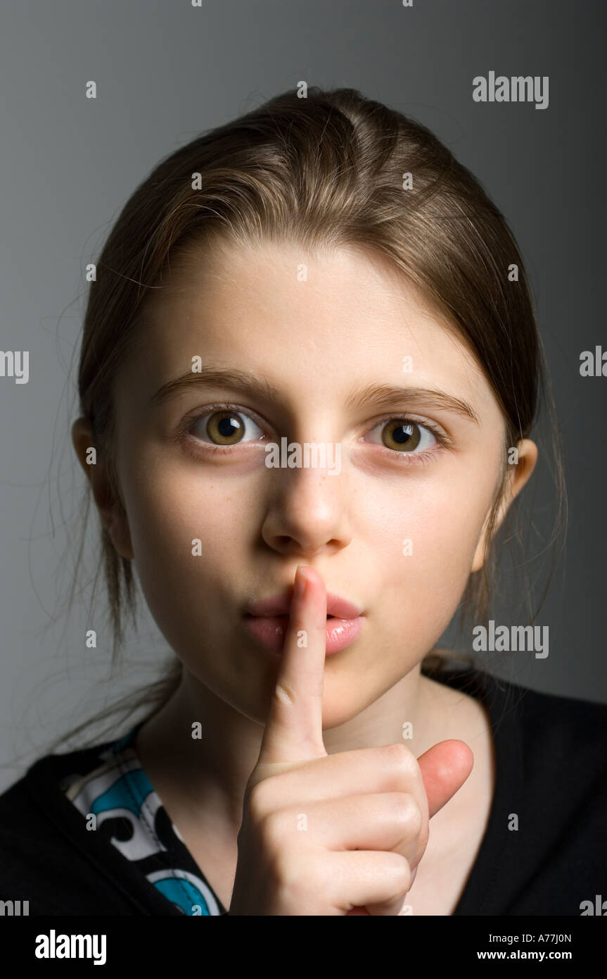 junges Mädchen mit Finger vor ihren Mund gestikulieren Stille Stockfoto