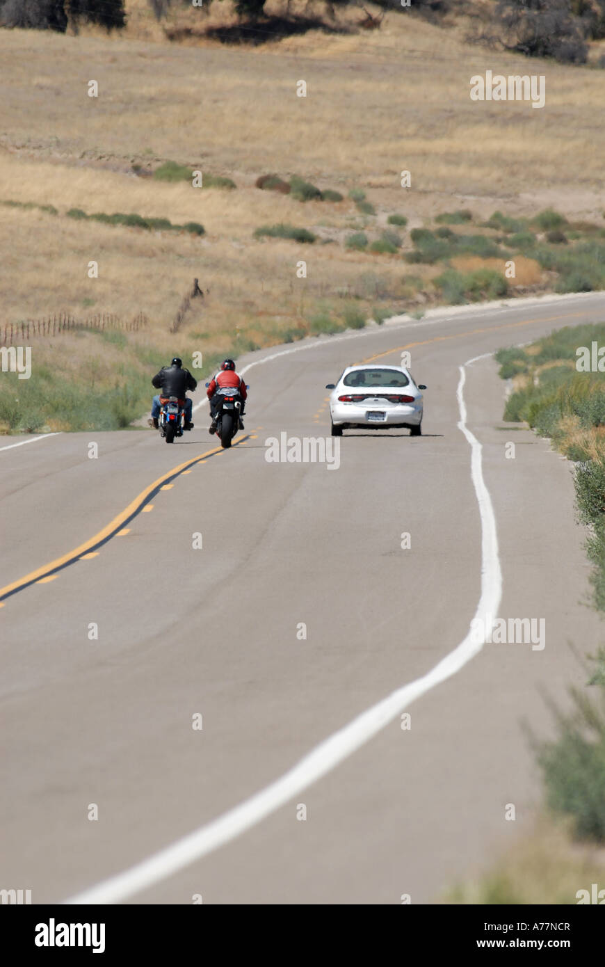 Zwei Motorradfahrer ein Auto vorbei Stockfoto