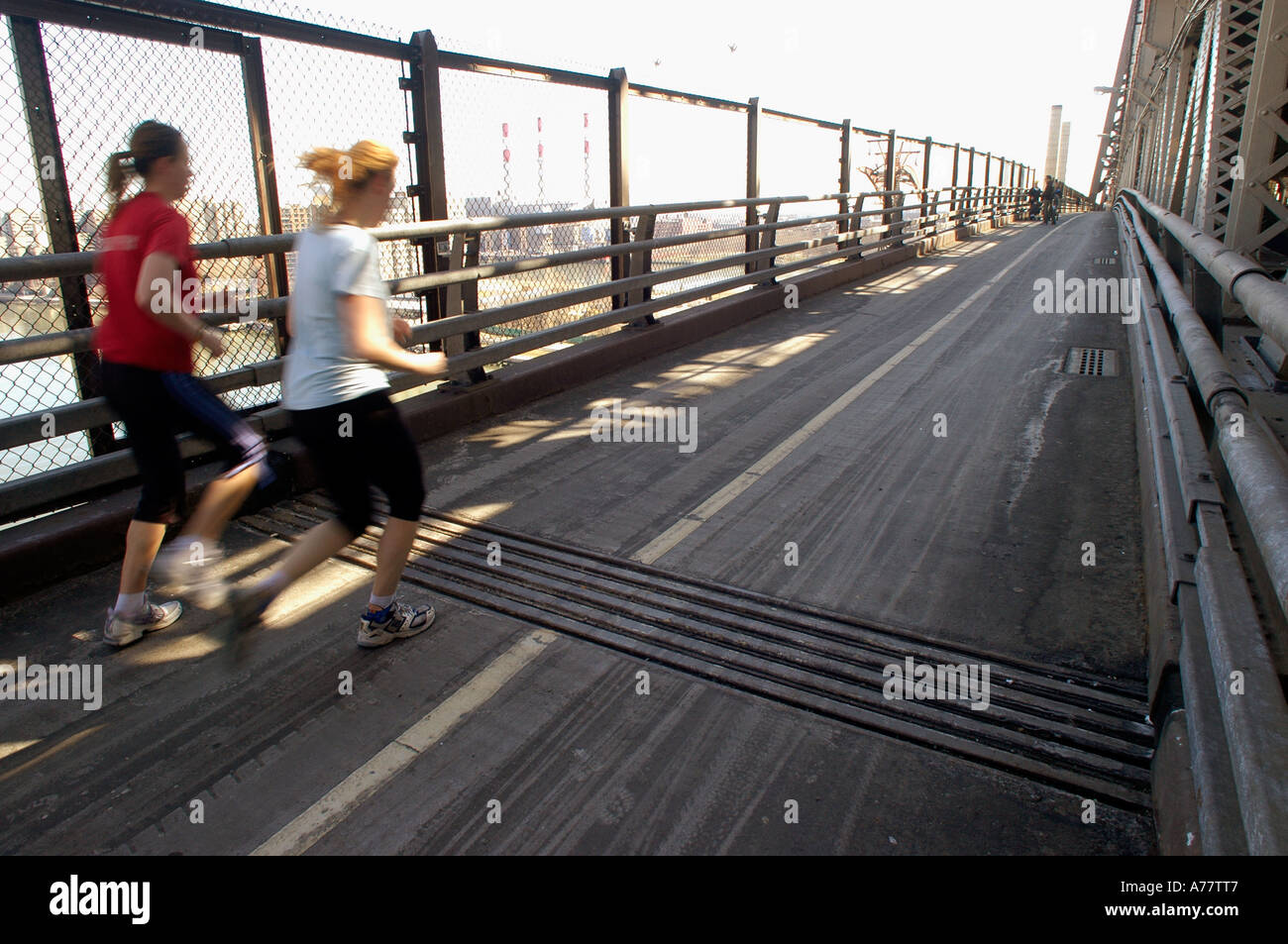 Jogger laufen über eine Dehnungsfuge auf dem Fußgängerweg auf die Queensboro Bridge über den East River in New York City Stockfoto