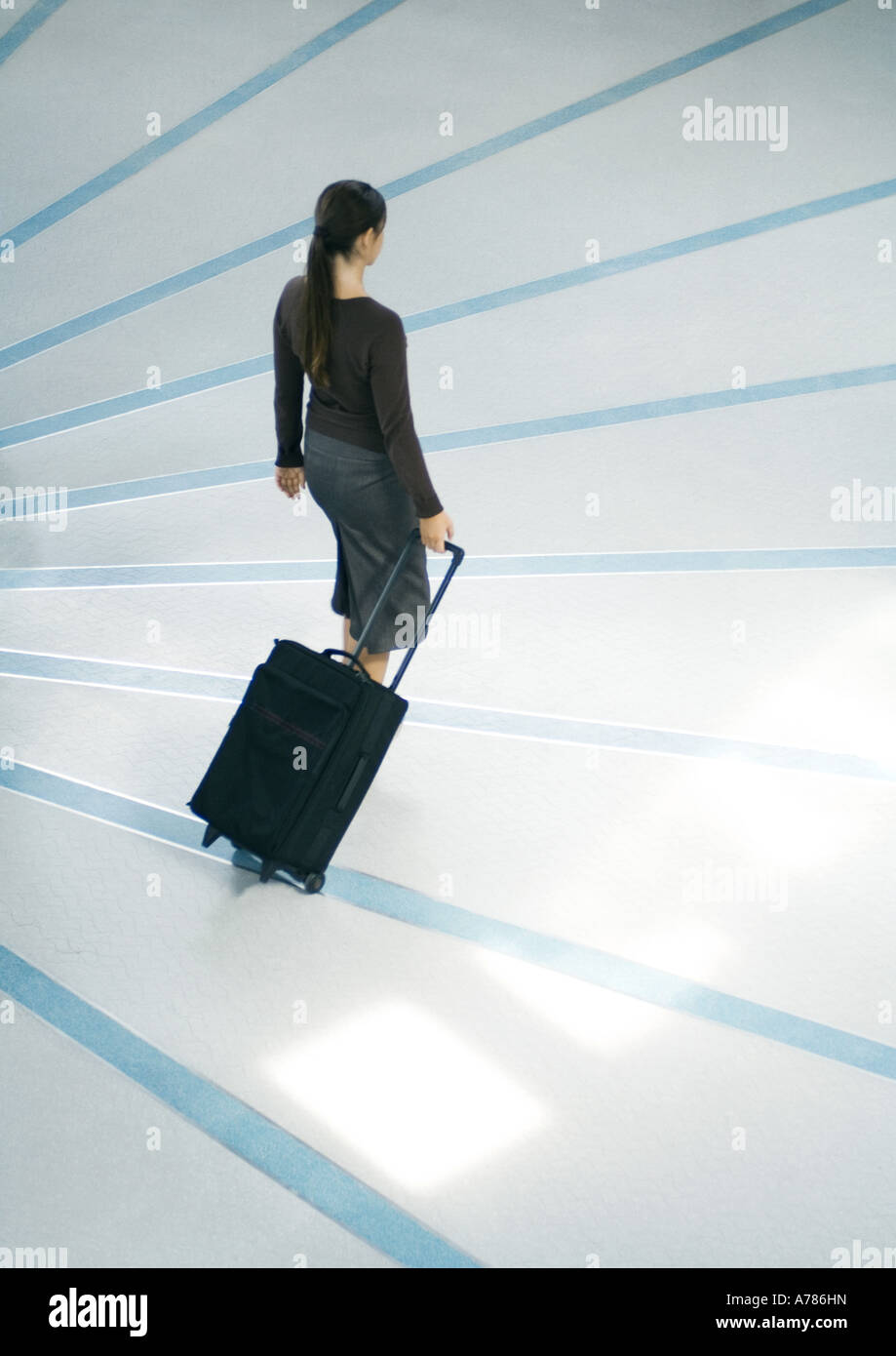 Frau zu Fuß mit Koffer, Ganzkörperansicht, erhöhte Ansicht Stockfoto