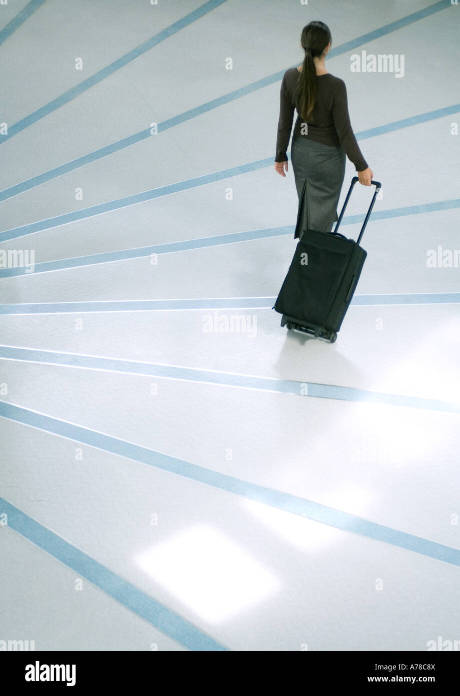 Frau zu Fuß mit Koffer, erhöhte hintere Ansicht Stockfoto