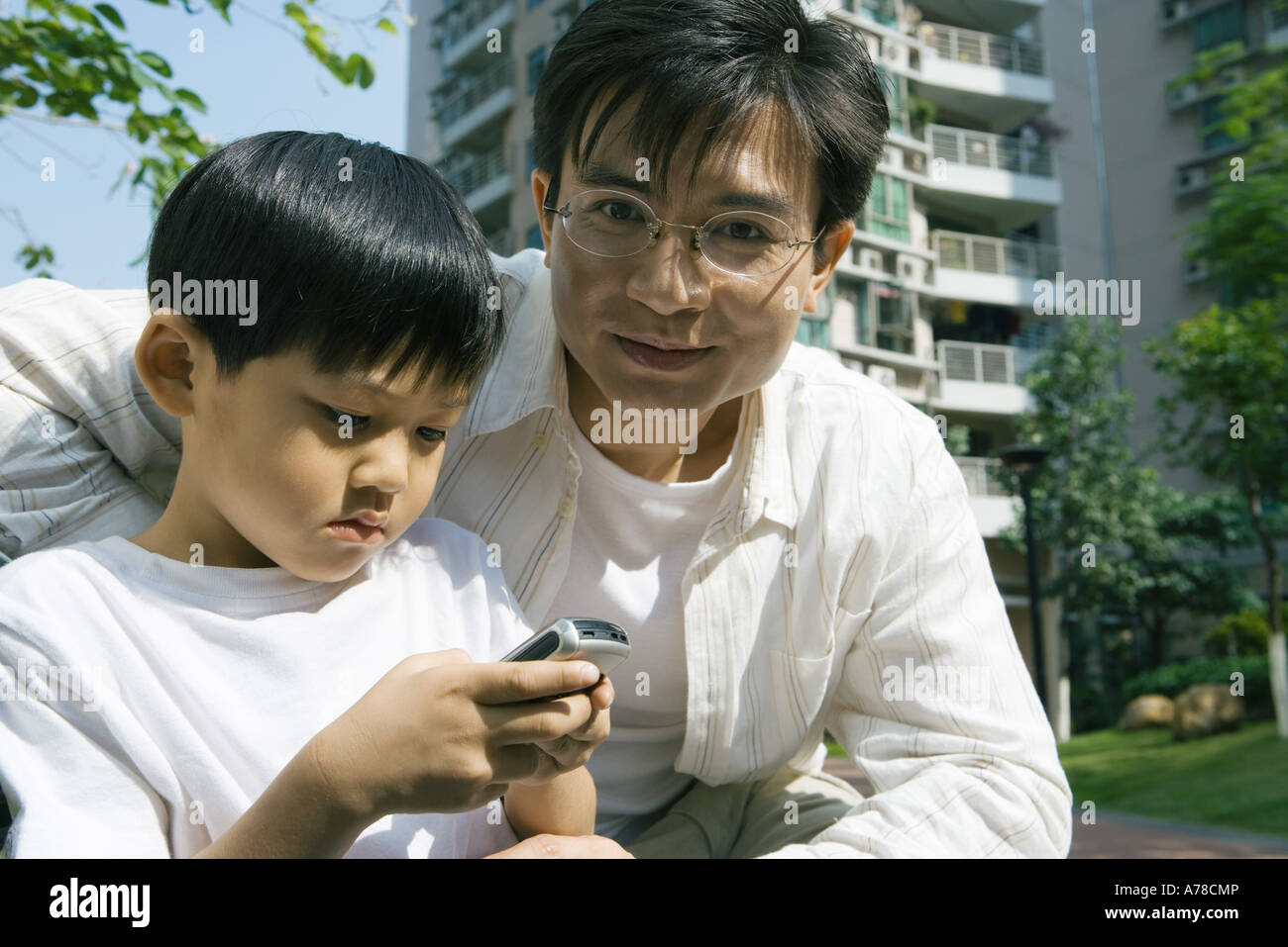Junge und Vater, junge mit Handy Stockfoto