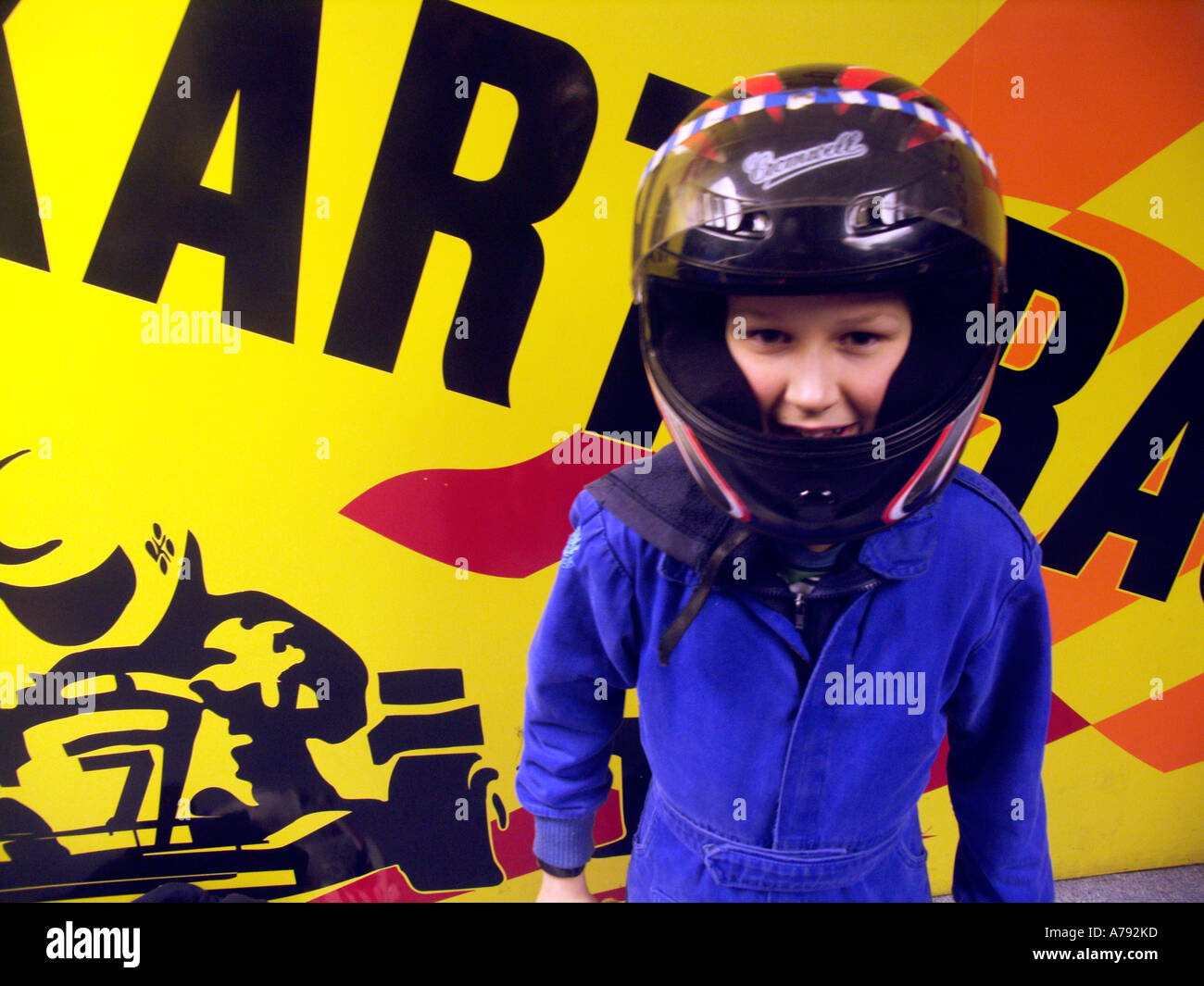 Junge für Go-Kart Rennen tragen Helm und blauen Overalls gekleidet Stockfoto