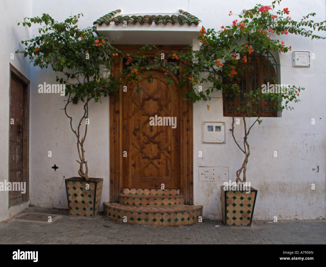 Weiß getünchte Gebäude und reich verzierte Eingangstür im Bereich Kasbah von Tanger, Marokko Stockfoto