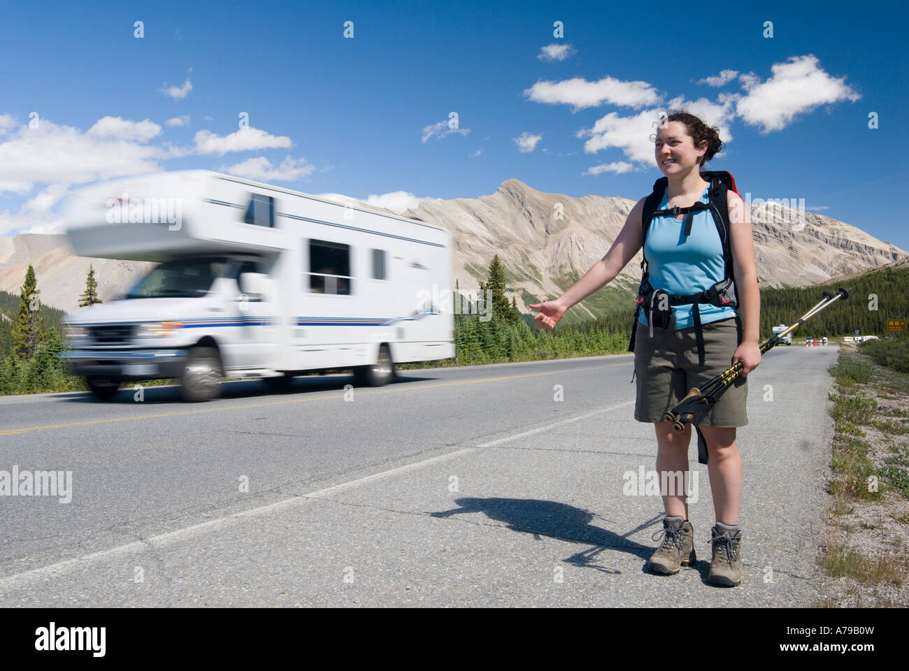Eine Frau Hitchiking auf dem Iclefields Parkway im Banff-Nationalpark AB als Wohnmobil vergeht Stockfoto