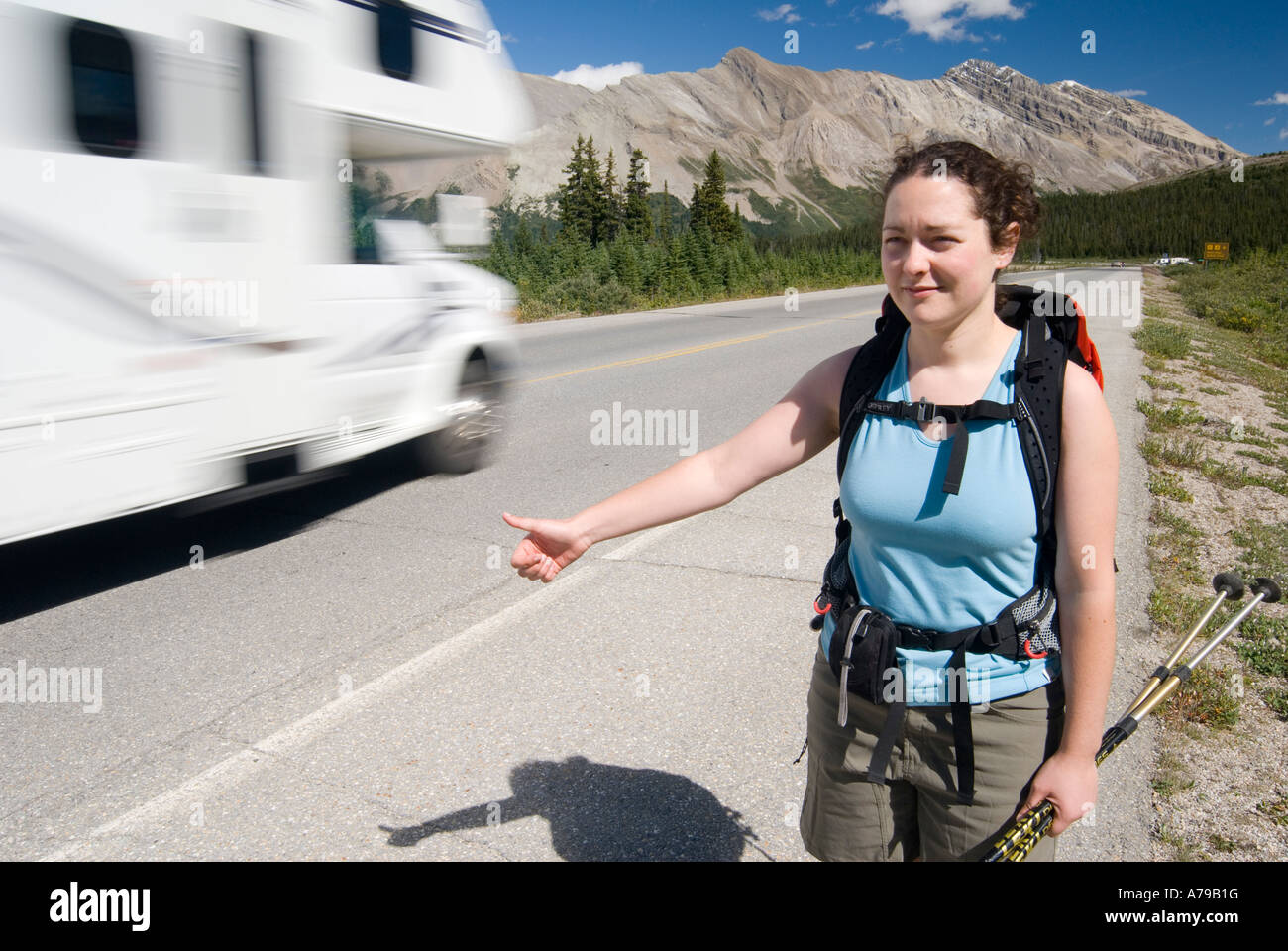 Eine Frau Hitchiking auf dem Iclefields Parkway im Banff-Nationalpark AB als Wohnmobil vergeht Stockfoto