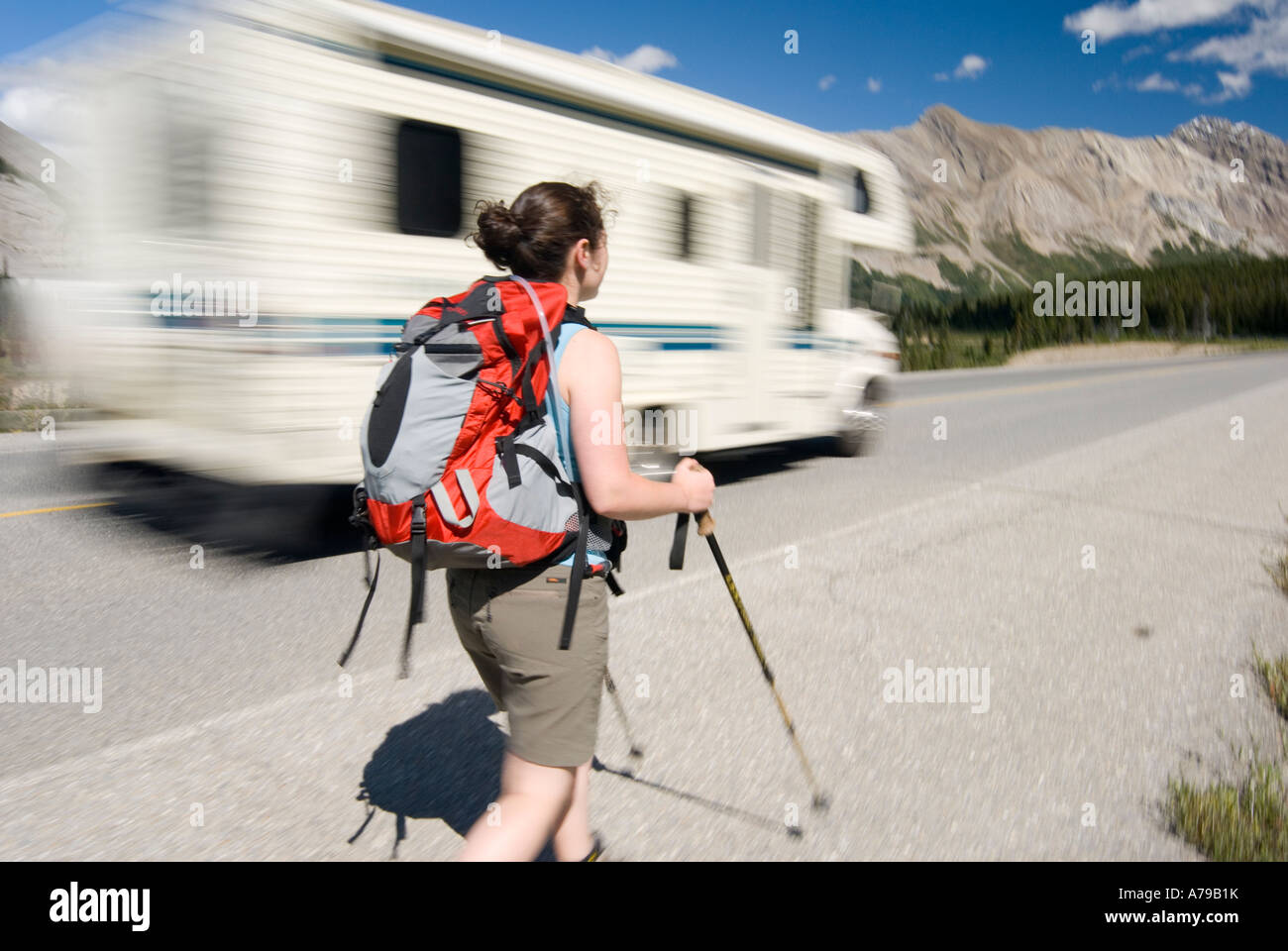 Eine Frau geht entlang der Iclefields Parkway im Banff-Nationalpark AB, wie ein Wohnmobil vergeht Stockfoto