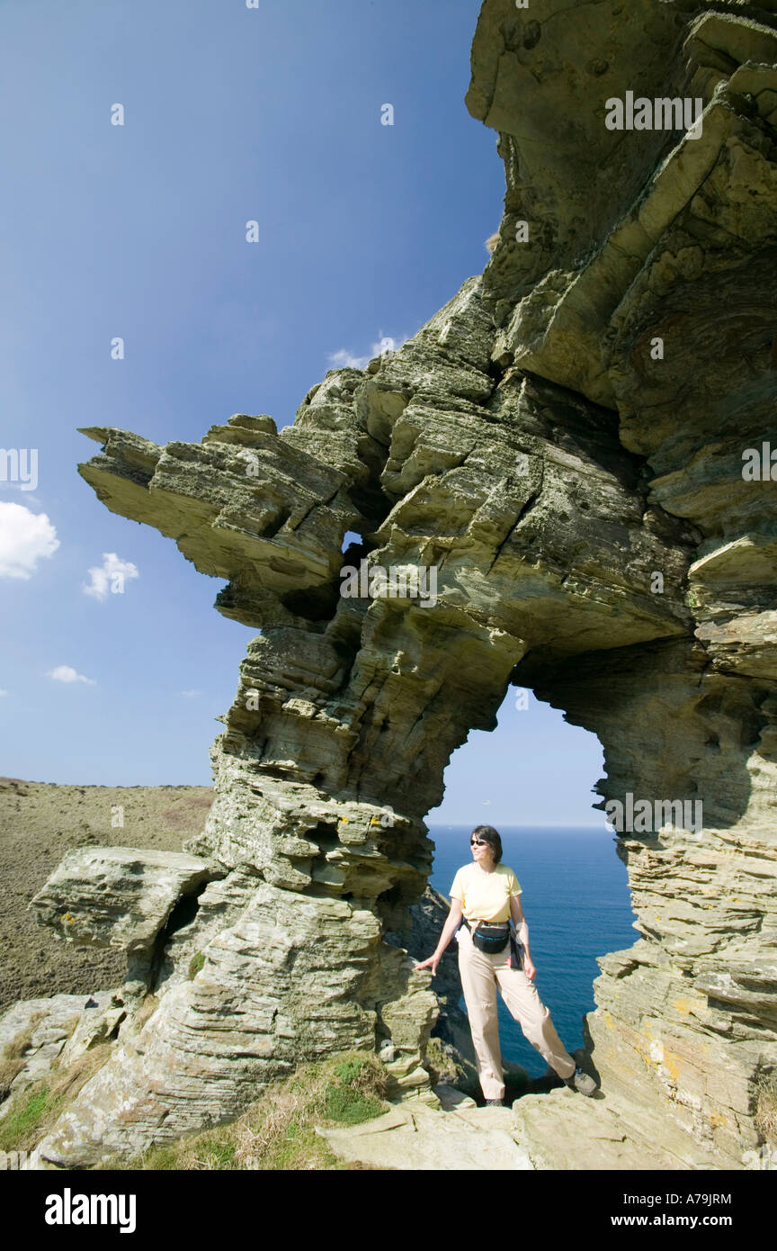eine Frau stand im Damen-Fenster eine Erosion-Funktion auf den Klippen in der Nähe von Tintagel, Cornwall, UK Stockfoto
