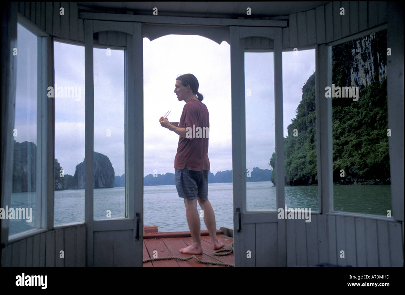 Touristen mit Stäbchen am Bug des Bootes in Ha Long Bay Golf von Tonkin nördlichen Vietnam Nein Herr Stockfoto