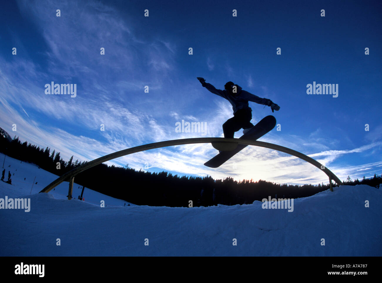 Silhouette Snowboarder gleitet eine Schiene in einem Snowboard-park Stockfoto