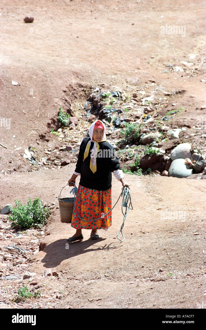 Eine Frau, die Wäsche in einem der vielen kleinen Dörfer unter dem Atlas-Gebirge in Marokko Nordafrika Stockfoto