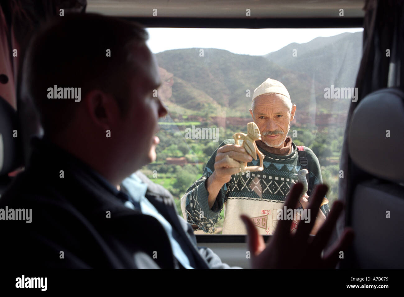 Eine Straße Verkäufer versucht, zu einem touristischen auf einen Bus in Marokko Nordafrika zu verkaufen Stockfoto