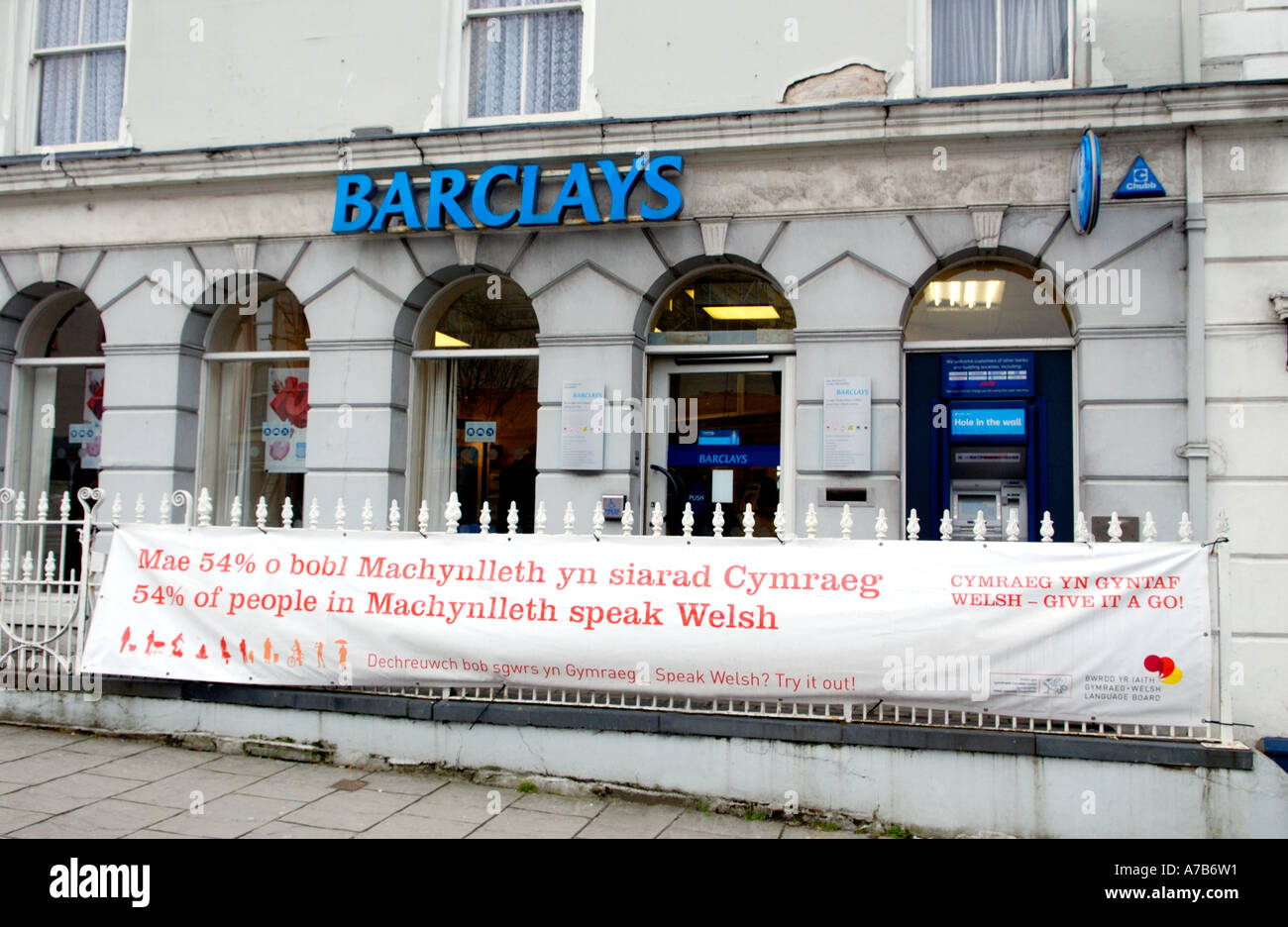 Welsh Language Board Banner hängen am Zaun außerhalb Barclays Bank in Machynlleth Powys Mid Wales UK Stockfoto