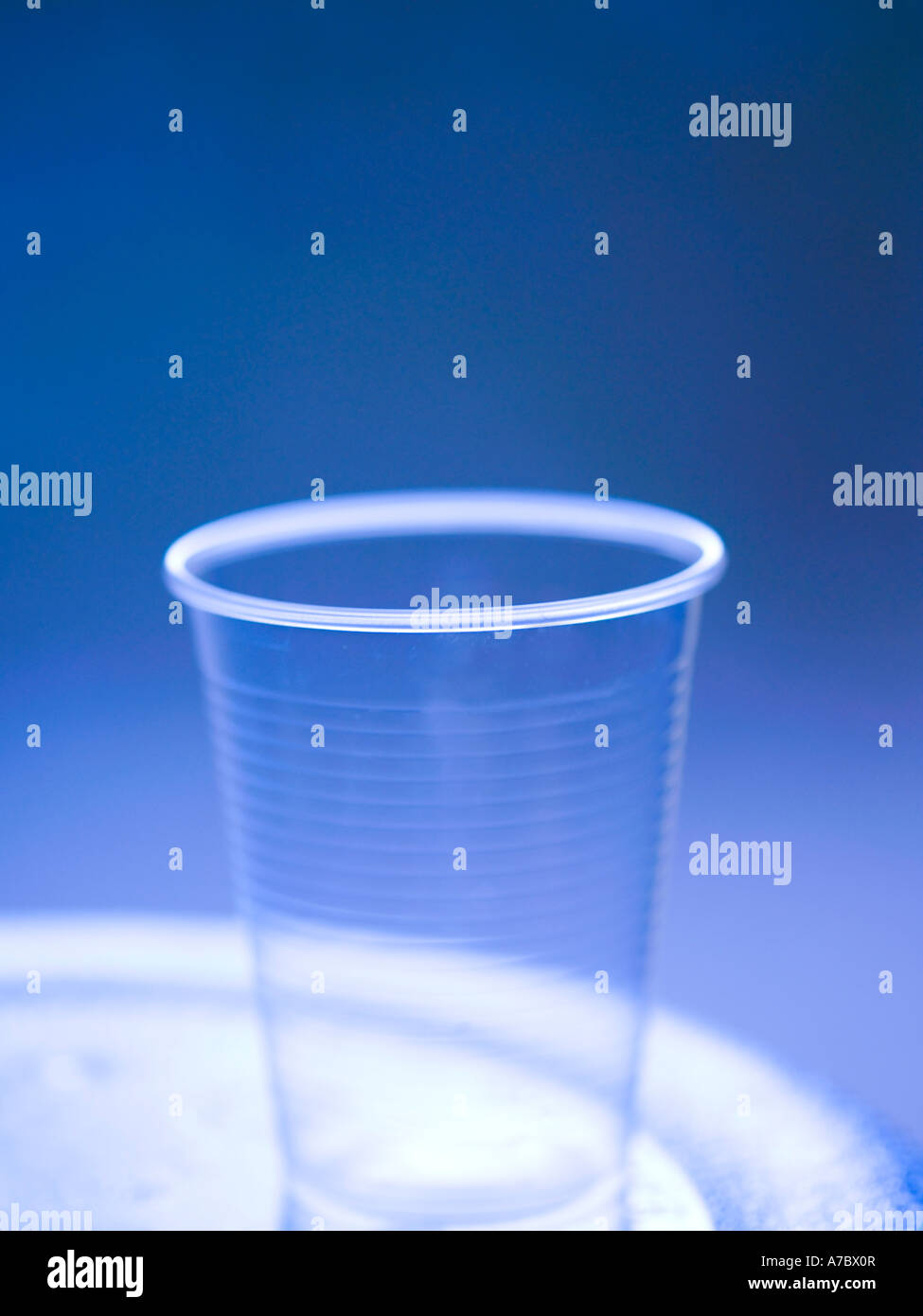 Kunststoff-Glas, transparent, Raghu, leicht, weich, blauer Hintergrund, Wasser, praktisch, Einwegartikel, zylindrische Form, Nahaufnahme Stockfoto