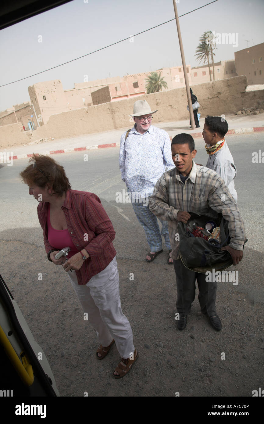 Touristen, näherte sich von jungen Männern, die versuchen zu verkaufen Souvenirs bei einem kurzen Stopp in ihrem Fahrzeug, Risani, Marokko Stockfoto