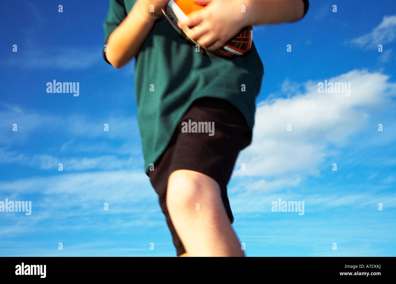 Junge mit Rugby-Ball laufen Stockfoto