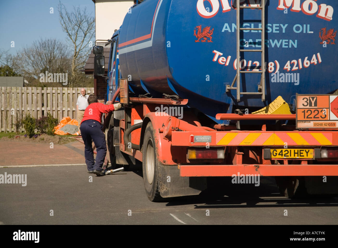 ISLE OF ANGLESEY NORTH WALES UK März ein Auslieferungsfahrer zurückziehen der Ölleitung haben Heizöl zu einem Haus geliefert Stockfoto