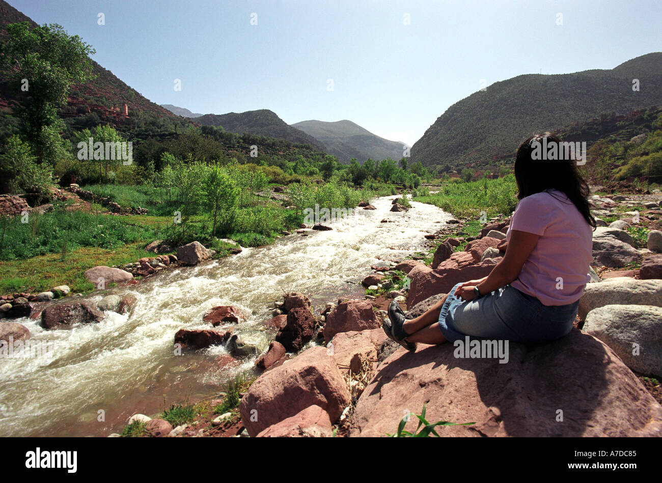 Ein Tourist schaut über einen Fluss unter dem Atlas-Gebirge in Marokko Nordafrika Stockfoto