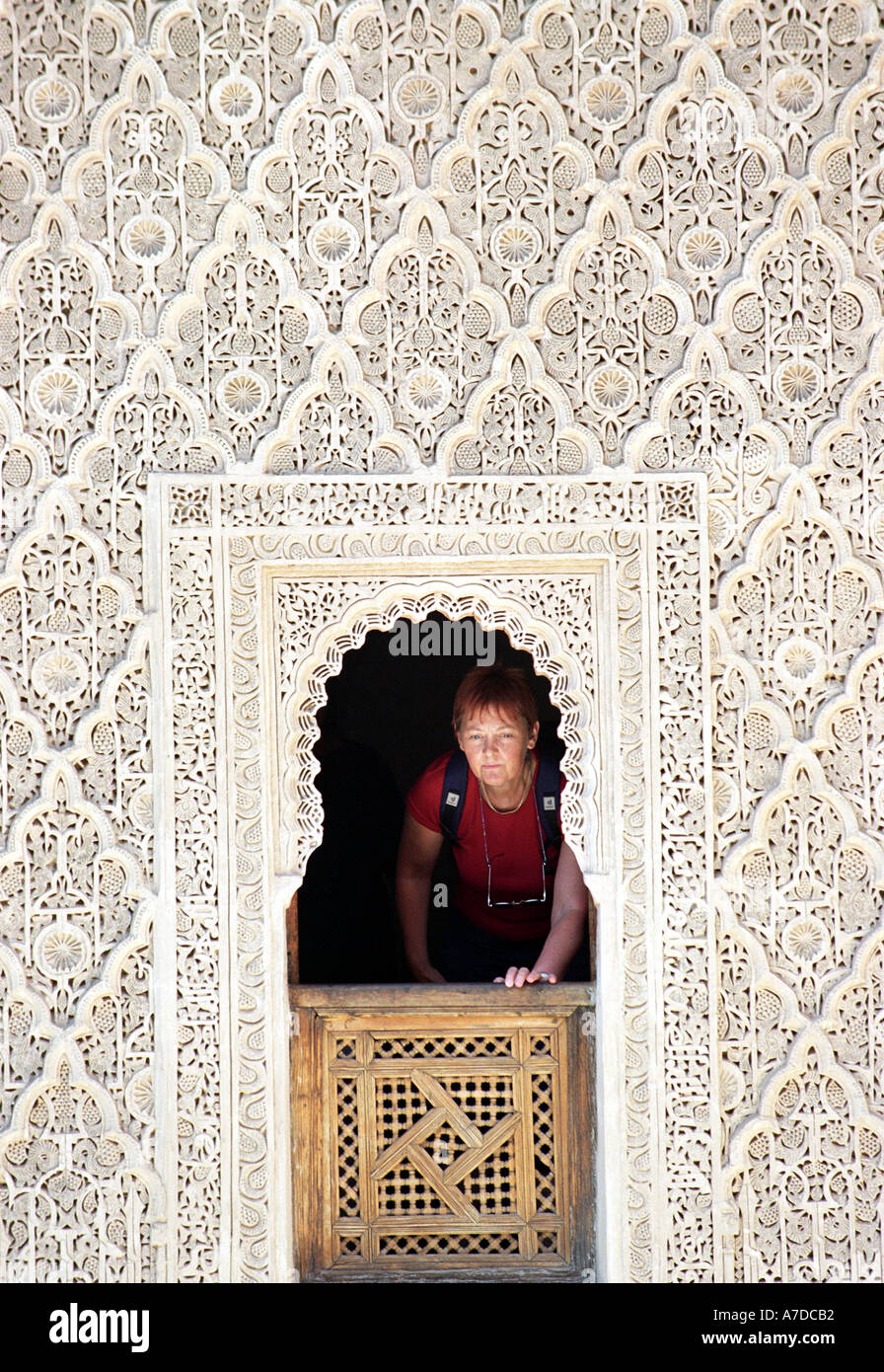 Ein Tourist schaut aus dem Fenster, La Medersa Ben Youssef in Marrakesch in Marokko Nordafrika Stockfoto