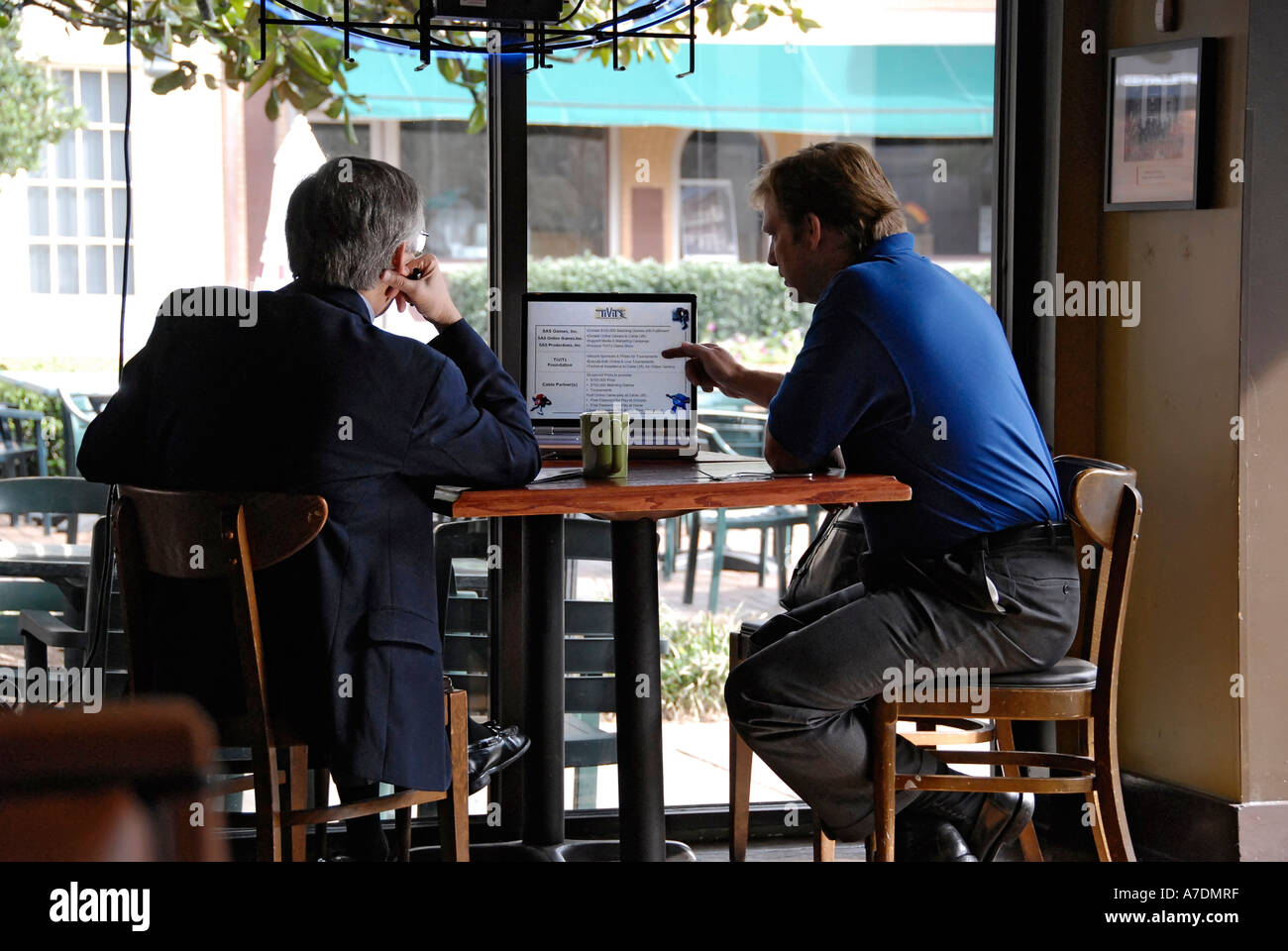 zwei professionelle Geschäftsleute Verhalten treffen mit einem Laptopcomputer als Hilfsmittel in einem Restaurant in der Mittagszeit Stockfoto