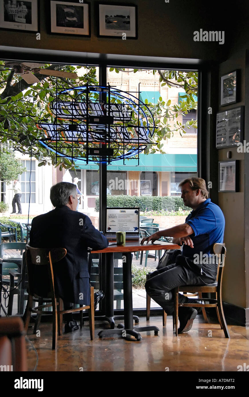 zwei professionelle Geschäftsleute Verhalten treffen mit einem Laptopcomputer als Hilfsmittel in einem Restaurant in der Mittagszeit Stockfoto