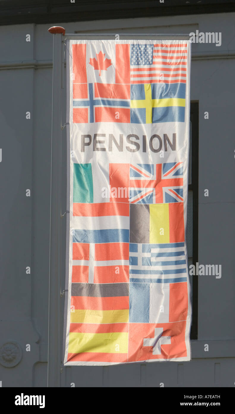 Verschiedene Flaggen auf ein Streamer vor ein Gästehaus in einer Touristenstadt Stockfoto