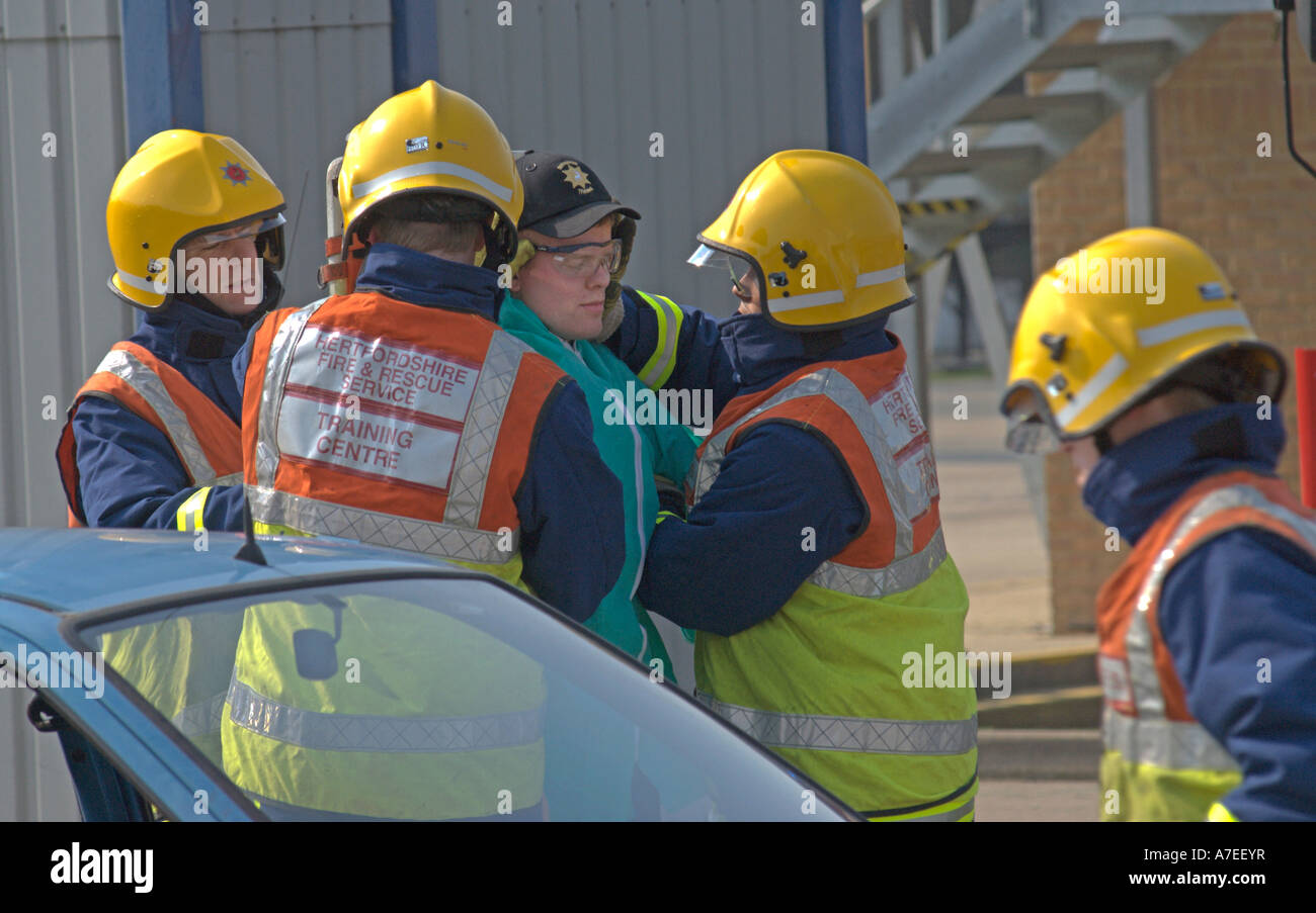 Feuer-Rekruten Tackle einem simulierten Verkehrsunfall als Bestandteil ihrer Weitergabe Zeremonie UK Stockfoto