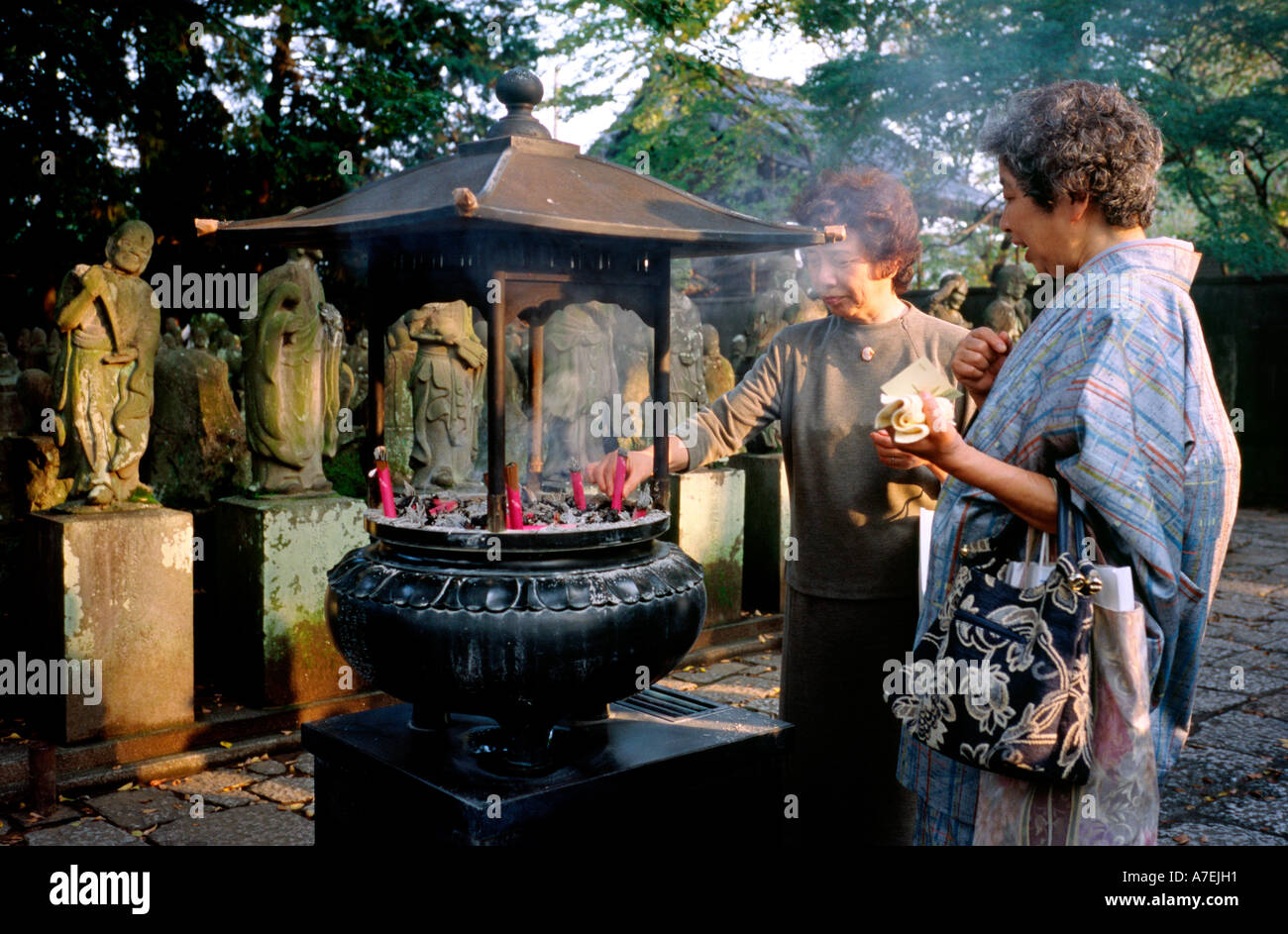 3. November 2004 - ältere Damen mit Inscense klebt an der Gohyaku Rakan (500 Jünger Buddhas) in Kawagoe (kleine Edo), Japan. Stockfoto