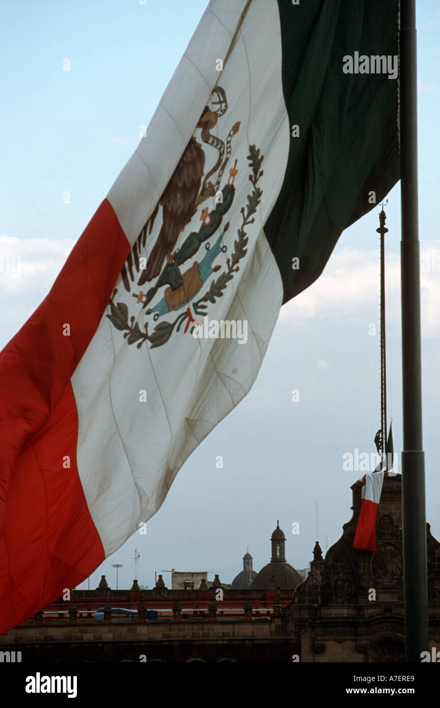 Ein Soldat senkt die Fahne vor dem Präsidentenpalast, umrahmt von mexikanischen Flagge über dem Zocalo. Stockfoto