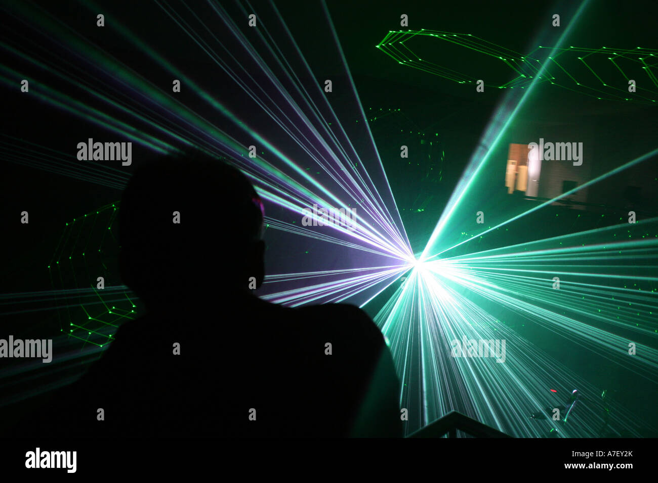 Ein Mann schaut in das Licht eines Lasers während einer Präsentation Stockfoto