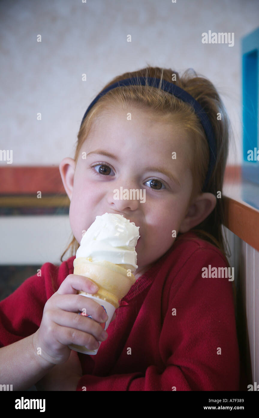 Vier Jahre altes Mädchen essen Eiscreme-Kegel-Modell veröffentlicht Stockfoto