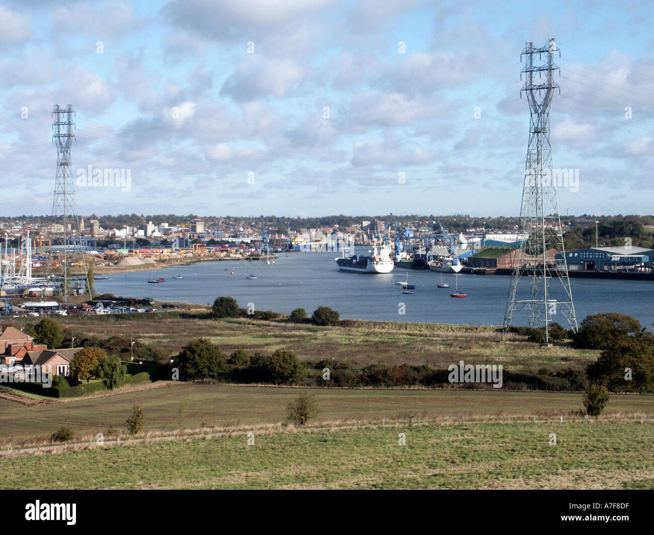 Städtische Landschaft Flut River Orwell bei Ipswich Schifffahrt & Hafen mit hohen Strommasten sonnigen blauen Himmel Tag in Suffolk East Anglia England Großbritannien Stockfoto