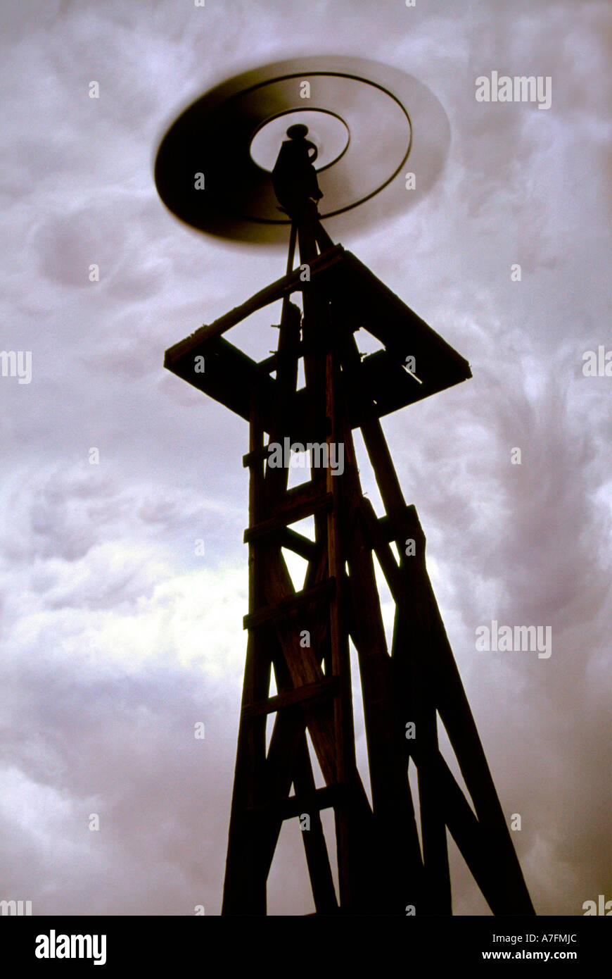 Eine herannahende Gewitter in den östlichen Ebenen von Colorado schafft eine unheimliche und surreale Szene mit diesem Silhouette Windmühle Stockfoto