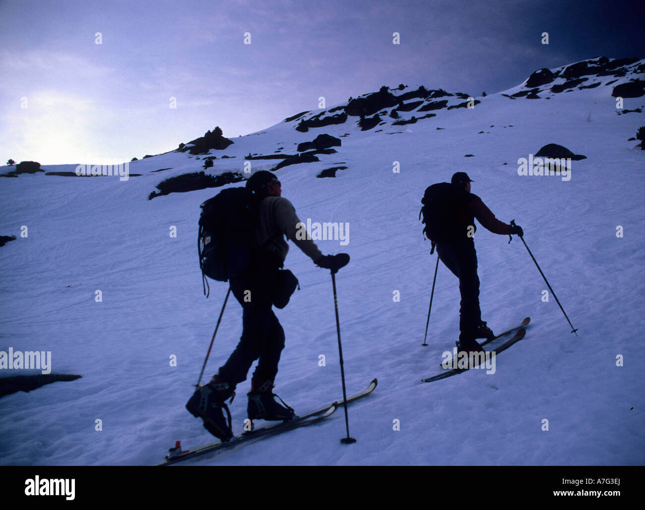 Zwei Ski-Alpinisten aufsteigend eine Schnee bedeckt Hang in den frühen Morgenstunden. Tessin, Schweiz Stockfoto