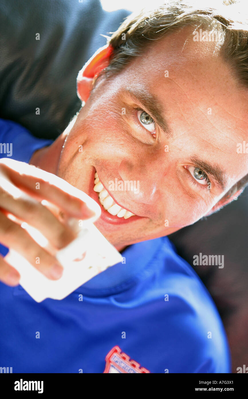 Nahaufnahme eines jungen Erwachsenen männlichen lächelnd mit Teetasse Stockfoto
