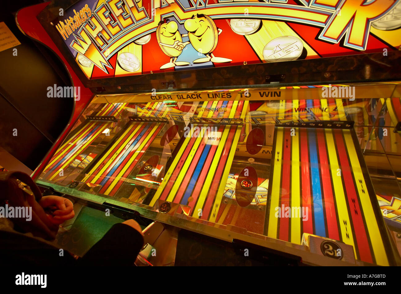 Person spielen Rollen eine Penny-Spiel in Spielhallen UK Stockfoto