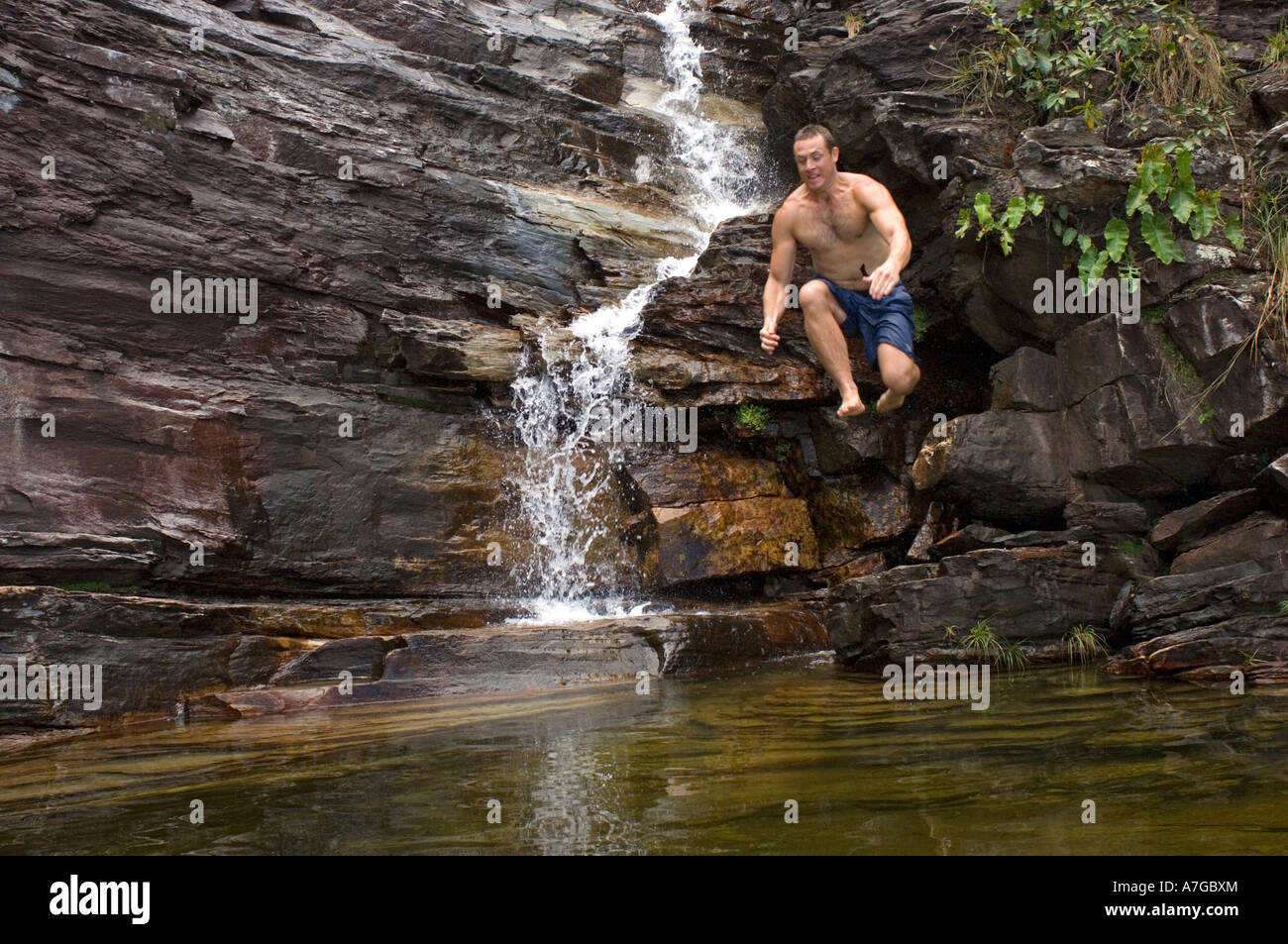 Ein Tourist, einem Sprung in einen der Felsformationen die natürlichen Wasserbecken in der Chapada Dos Veadeiros Nationalpark zu schaffen. Stockfoto