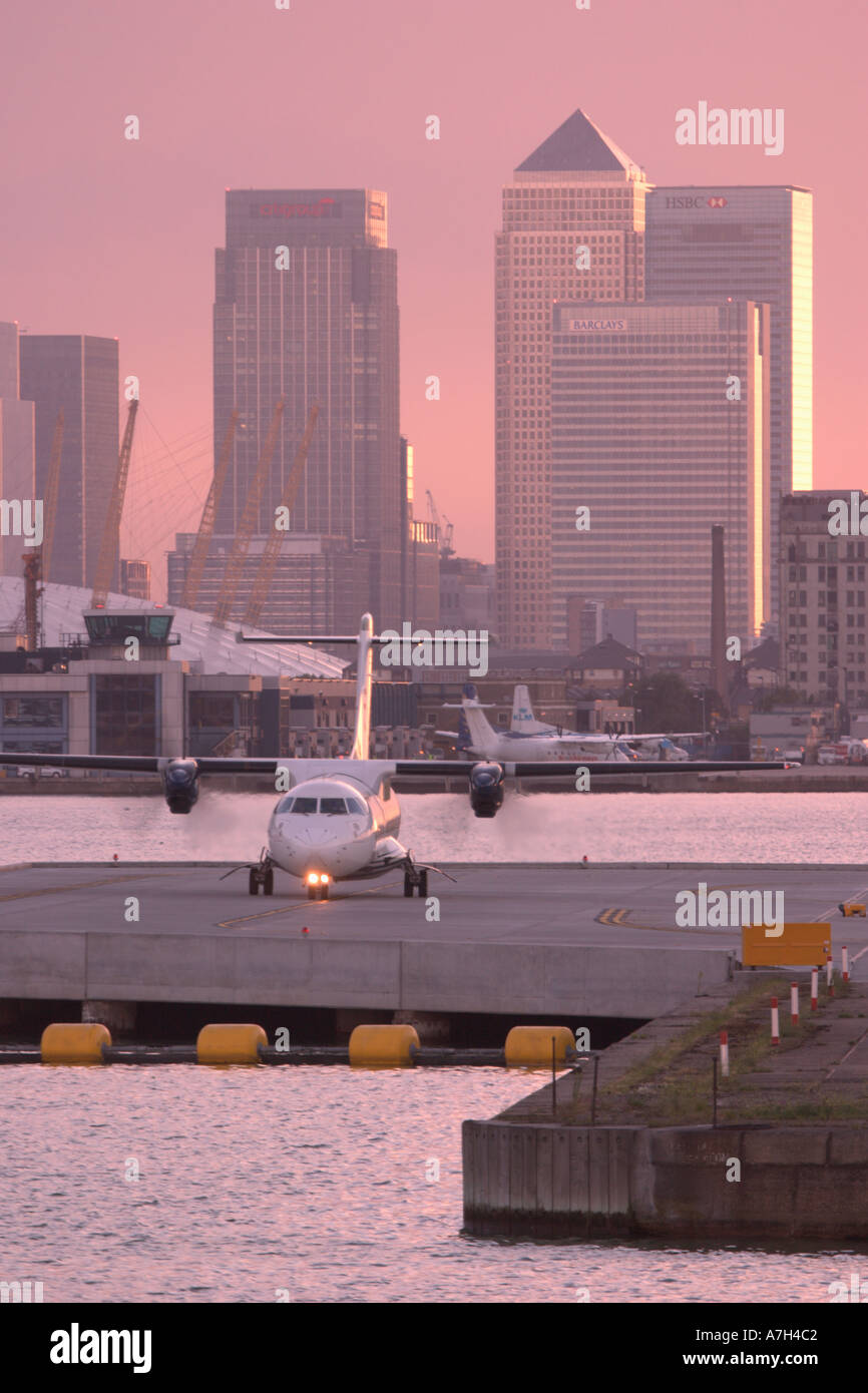 Turboprop-Regionalflugzeug Besteuerung am London City Airport mit Millenium Dome und Canary Wharf im Hintergrund Stockfoto