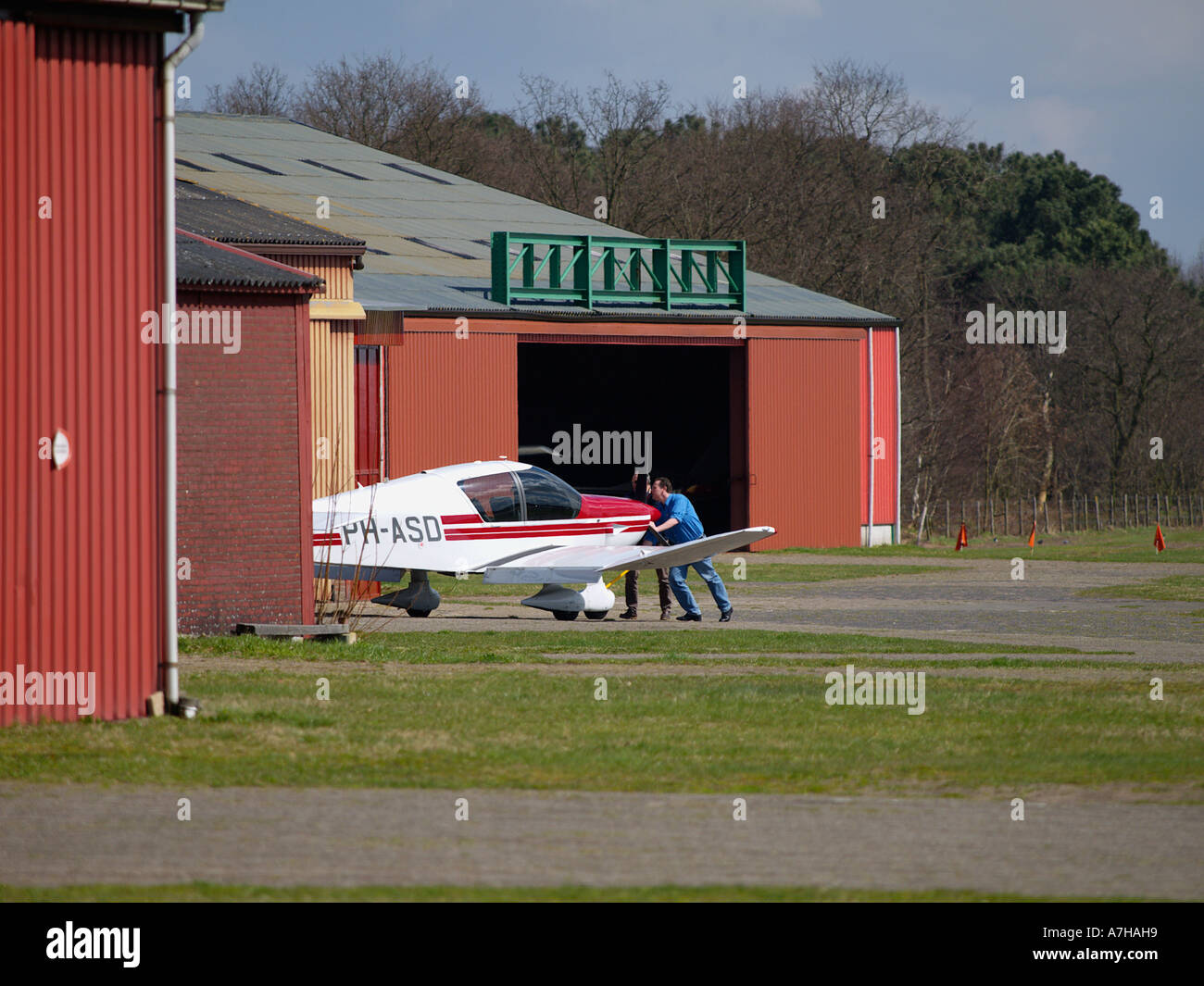 Zwei Männer drücken ihre kleinen Flugzeug in einem Hangar auf Seppe Flugplatz Noord Brabant, Niederlande Stockfoto