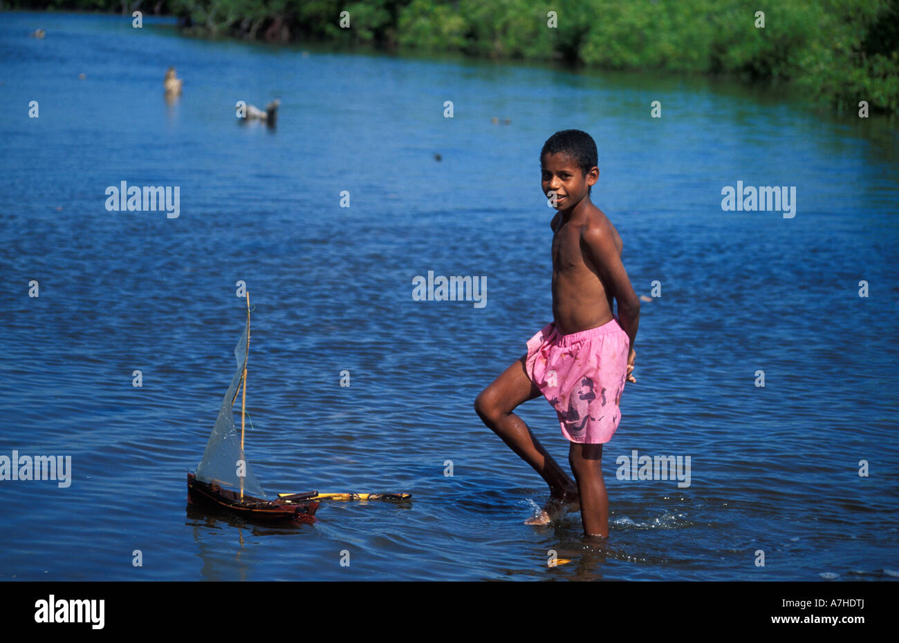 Suaheli junge spielt mit seinem kleinen Dhau am Stadtrand Siyu, Pate Insel Lamu-Archipel, Kenia Stockfoto