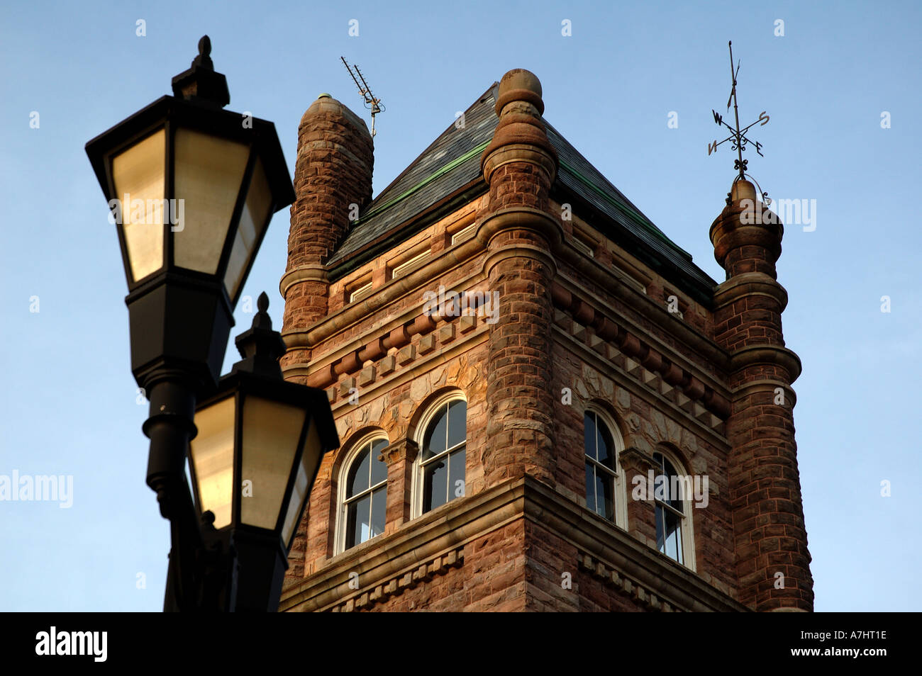 Ein Foto von einer alten Laterne mit einem reichen architektonischen Gebäude im Hintergrund alte reiche architektonische Architektur Lampe p Stockfoto