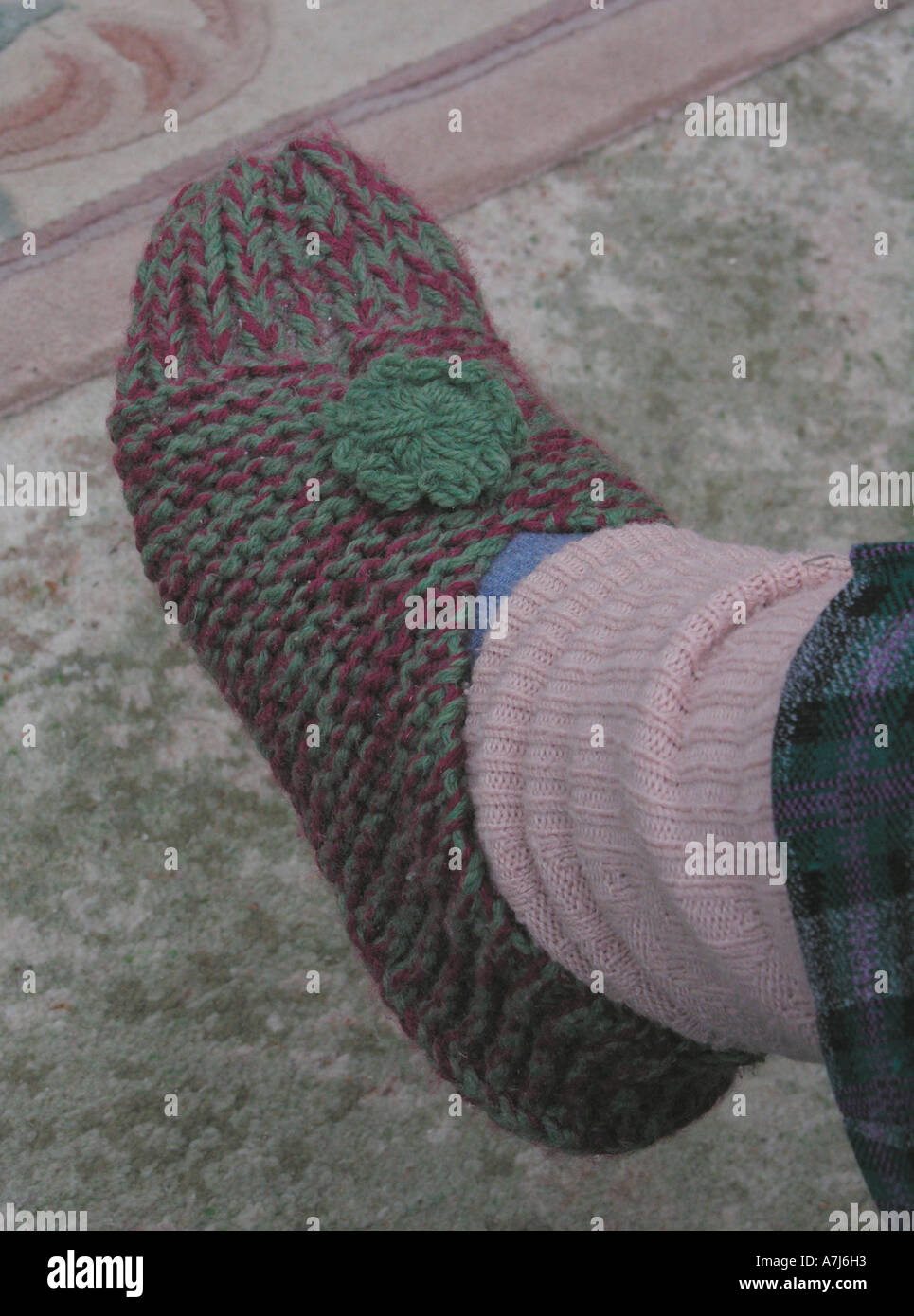 ältere Frau Beinlinge und gestrickte Hausschuhe tragen, halten warm und gemütlich im winter Stockfoto