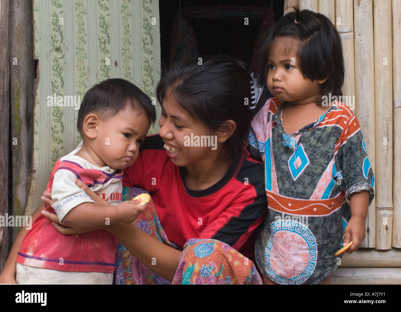 Eine thailändische Mutter und Kind auf ihrer Veranda in dem muslimischen Dorf von Tung Nang Damm befindet sich auf der North Andaman Sea-THAILAND Stockfoto