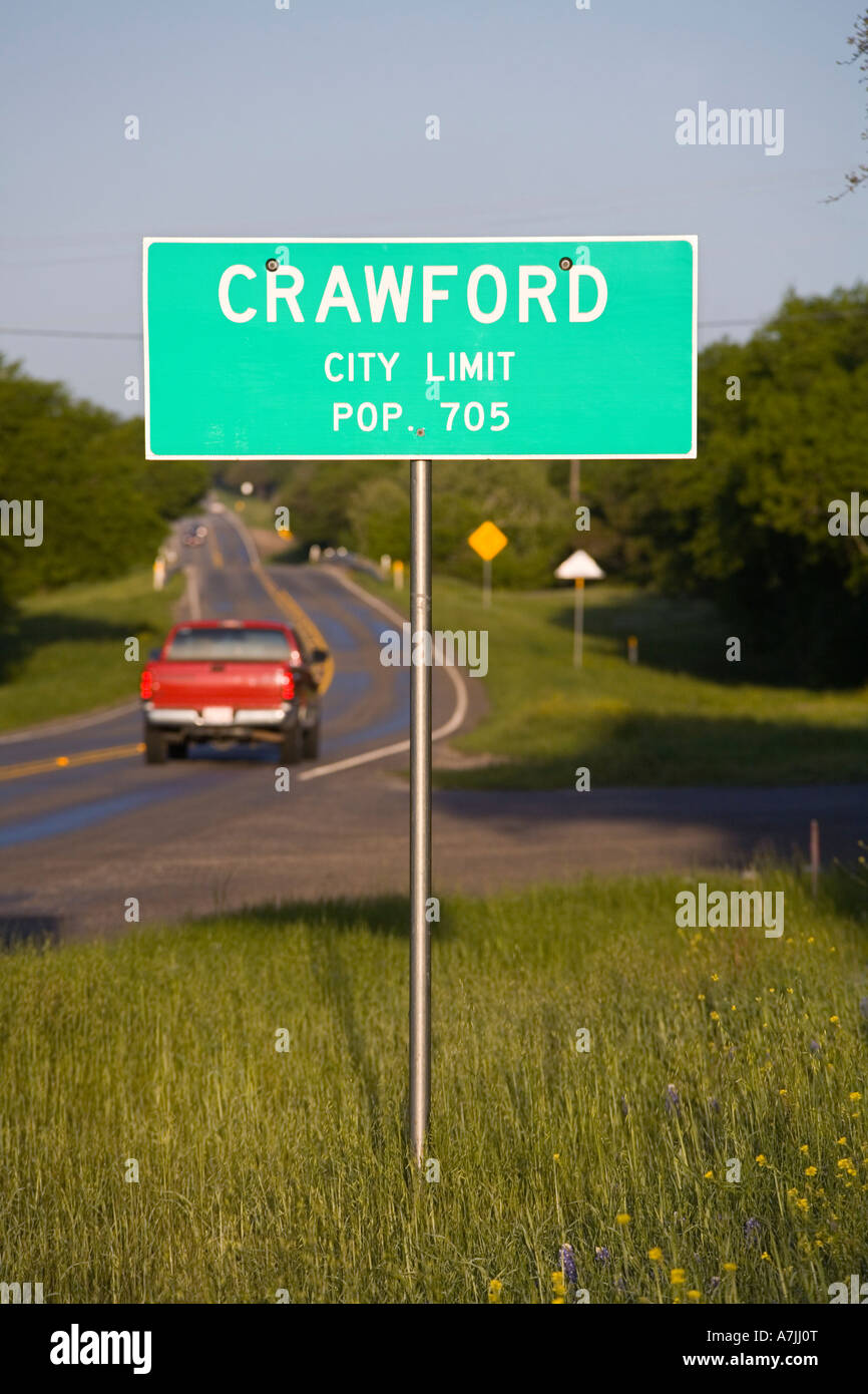 Crawford, Texas, Ortsschild, roter Pickup und Straße. Stockfoto