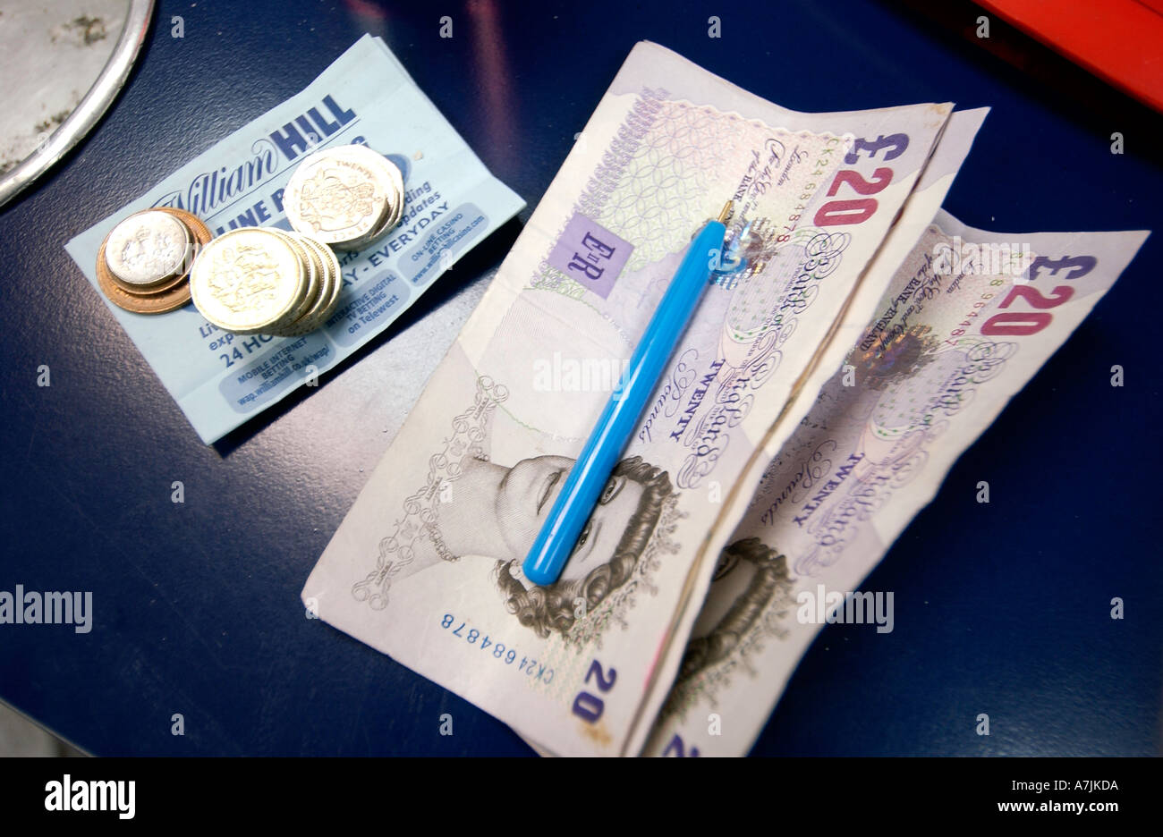 Geld stellt fest, Münzen und einen Buchmacher-Stift Stockfoto