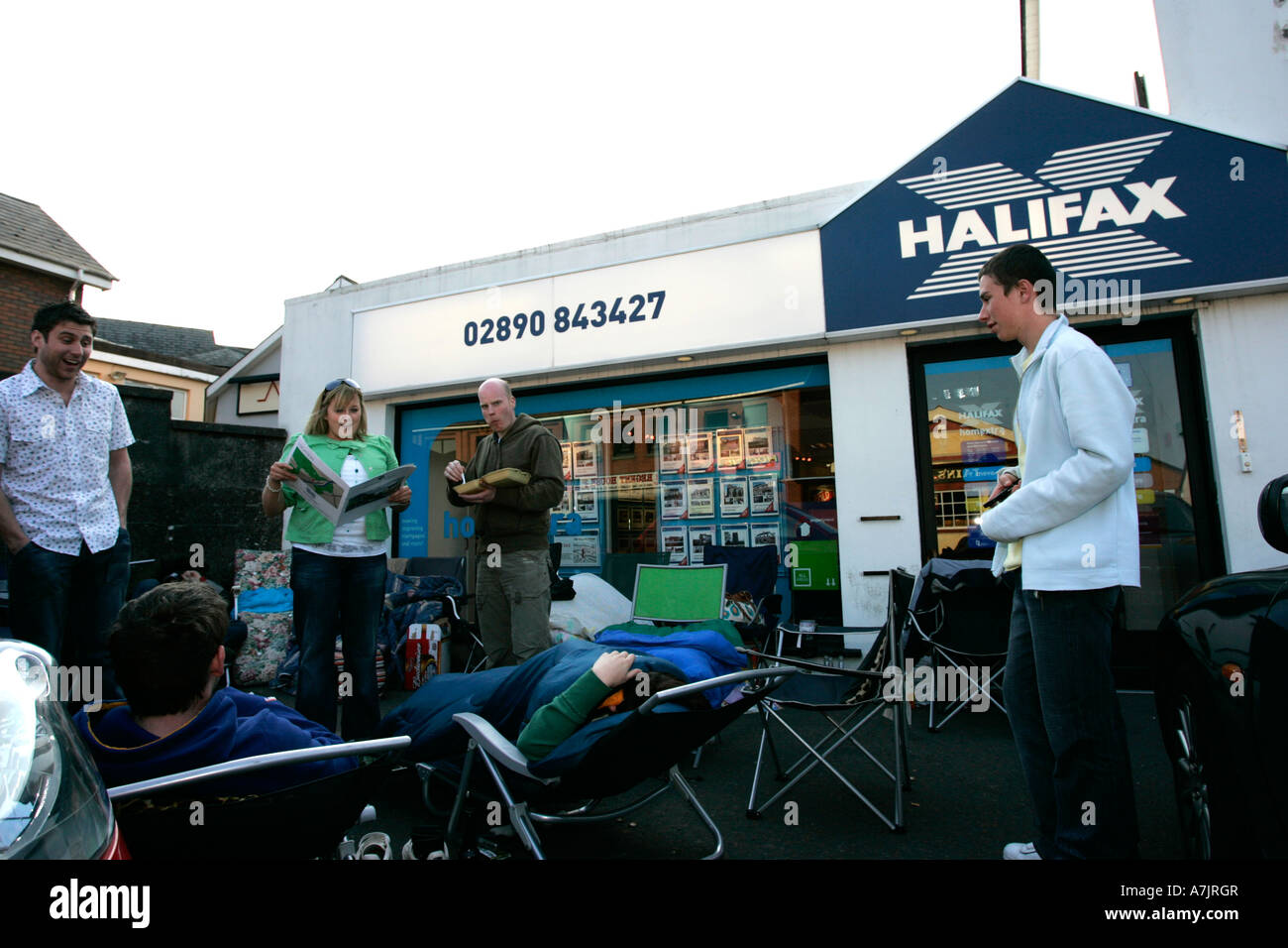 Eine Gruppe von Erstkäufern, die vor der Immobilienagentur in Nordirland standen und warteten, wartete auf die Veröffentlichung der neuen Entwicklungs-Spitzenblase 2007 Stockfoto