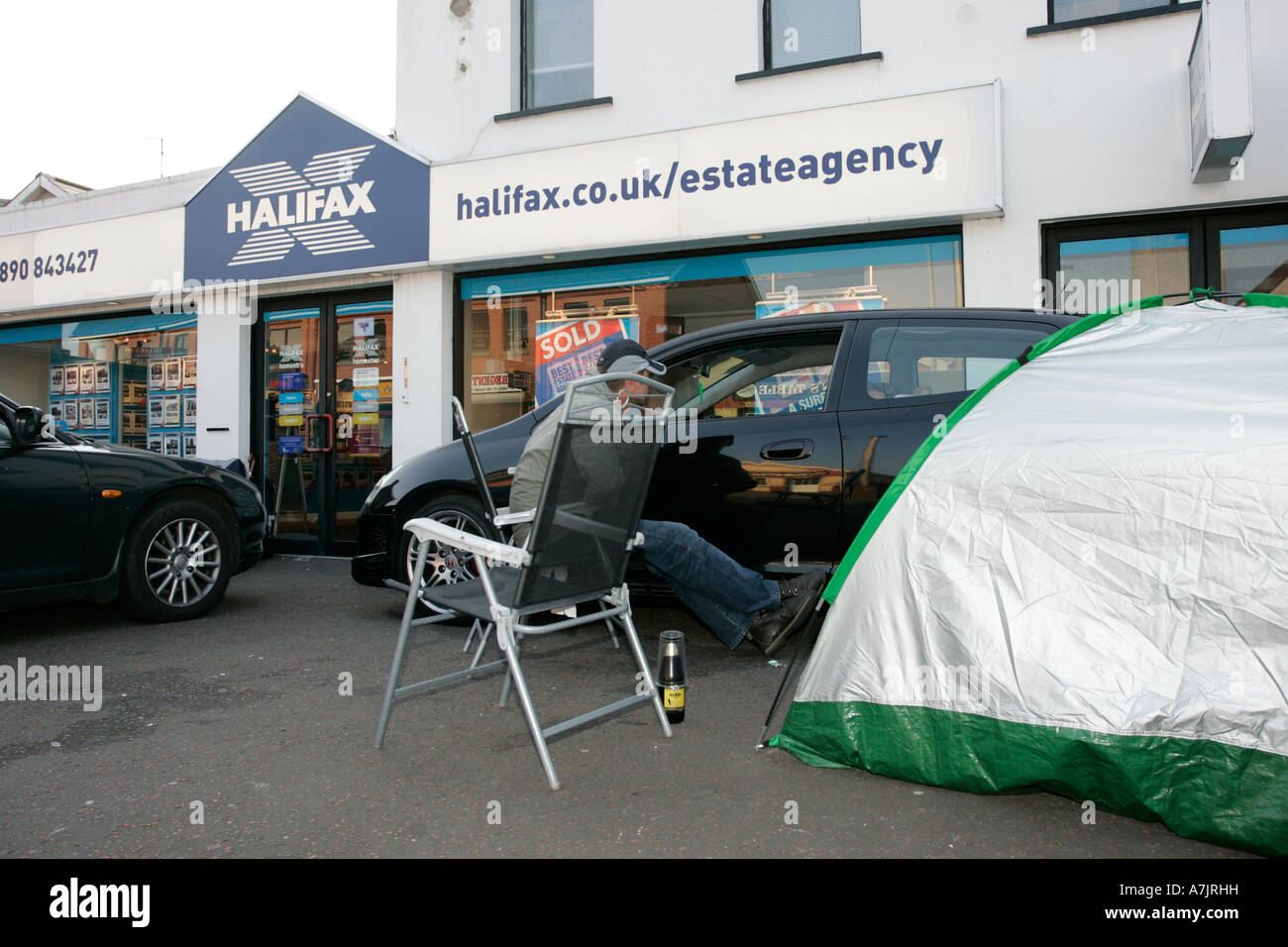 Eine Gruppe von Erstkäufern lagerte außerhalb einer Immobilienagentur in Nordirland mit Autos und Zelt, die während der Immobilienblase von 2007 auf die Freilassung warteten Stockfoto