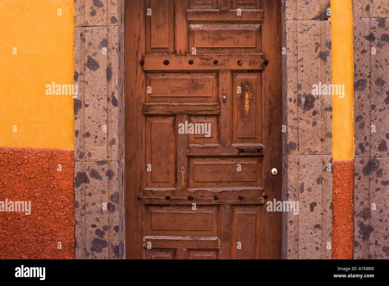 Mauerwerk-Holztüren und leuchtend orange-rote Farbe sind Teil des architektonischen Stils von SAN MIGUEL DE ALLENDE, Mexiko Stockfoto