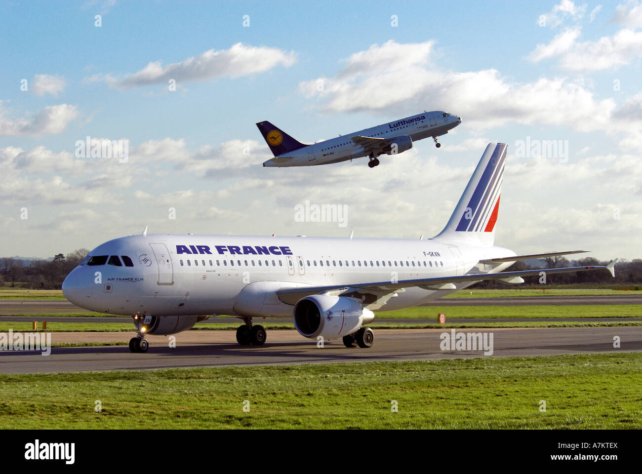 Eine Air France Airlines Airbus A320 Rollen mit einem Lufthansa-Airbus im Hintergrund abheben. Stockfoto